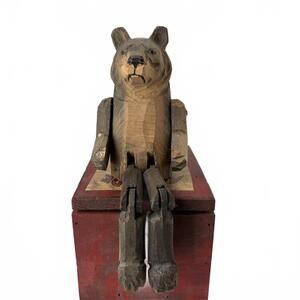 Vintage hand-carved wooden bear with jointed limbs, folk art style.